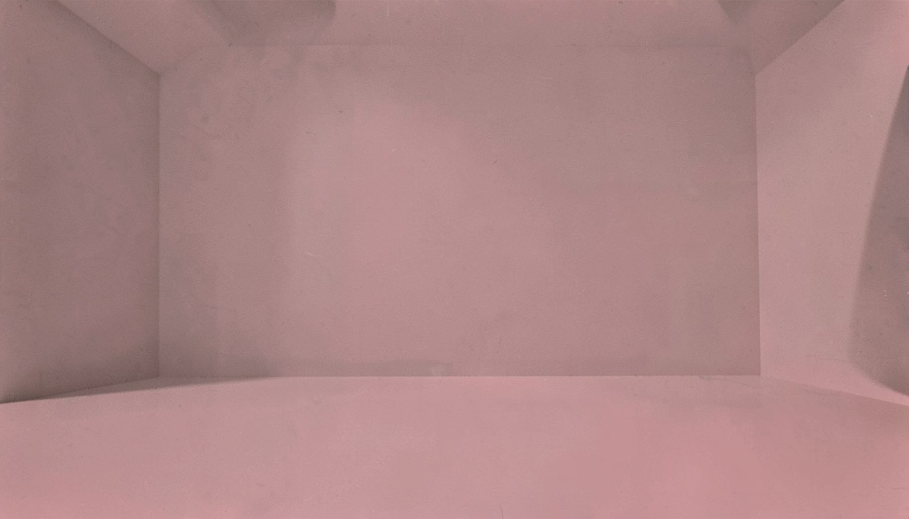 A duotone photograph in charcoal and soft red tones showing a calm empty space with simple geometric shapes